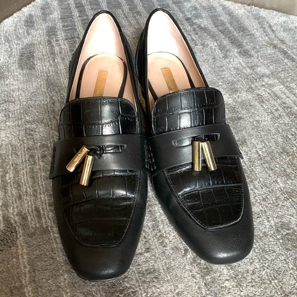 Black leather loafers with gold tassels